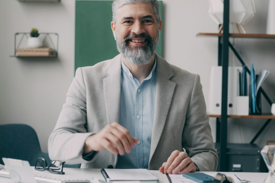 Smiling accountant reviewing paperwork at his desk